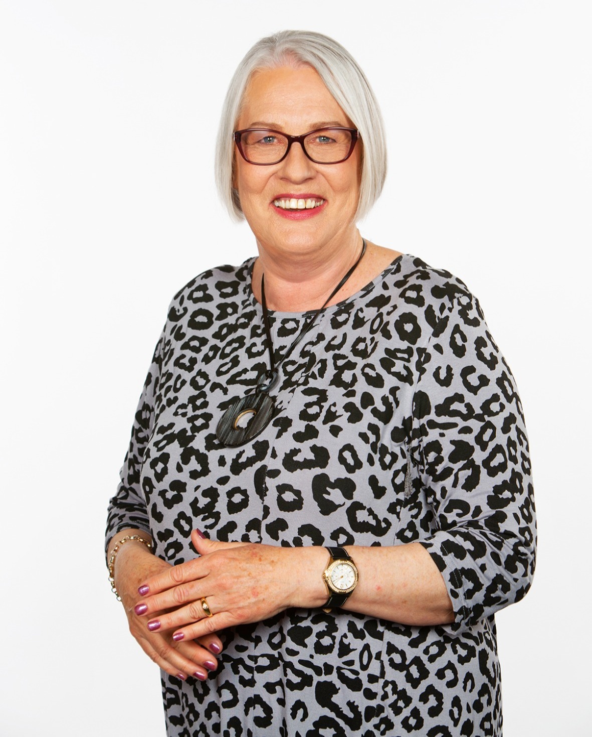 Robinanne Lavelle, smiling, silver hair and tortoiseshell glasses.